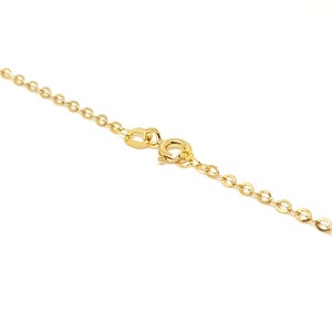 May include: A delicate gold necklace with a small oval link chain and a spring ring clasp. The necklace is set against a white background, highlighting its bright, shiny appearance. The chain is a classic design, suitable for everyday wear.