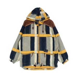 May include: A hooded jacket featuring a plaid pattern in navy blue, mustard yellow, and light gray. The garment includes a full-length front zipper, brown shoulder panels, two zippered waist pockets, and a small black label with white text.