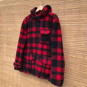 May include: A red and black plaid hooded jacket with a button closure and multiple pockets.