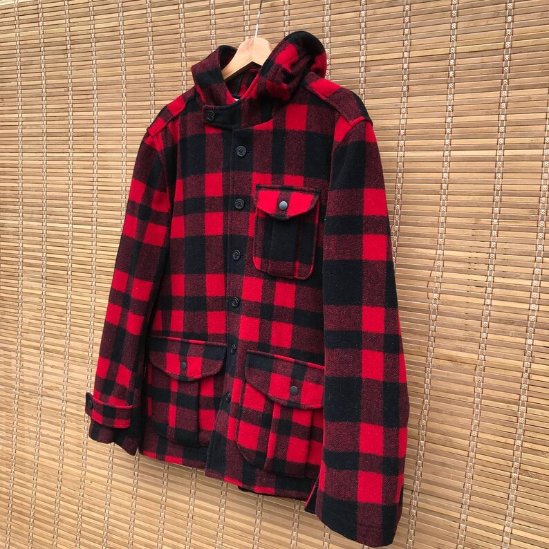 May include: A red and black plaid hooded jacket with a button closure and multiple pockets.