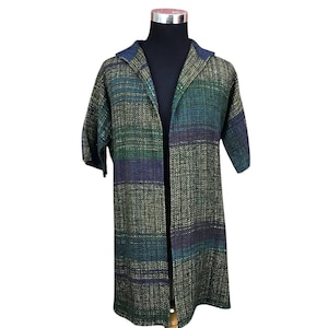 May include: A long, open-front coat with short sleeves, displayed on a mannequin. The coat features a woven fabric in shades of green, blue, and gold. The collar is a darker blue. The coat has a knee-length hemline.