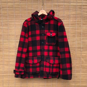 May include: Red and black plaid hooded jacket with a button closure and two large pockets.