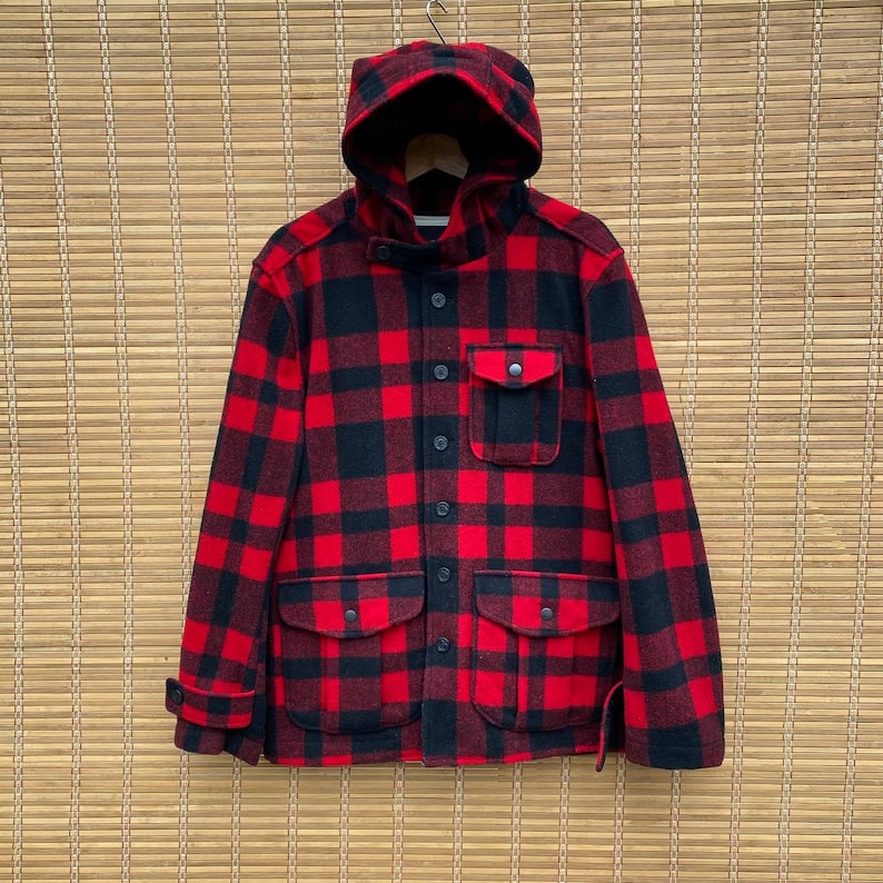 May include: A red and black plaid hooded jacket with a button front and two large pockets. The jacket is made of a thick, warm material.
