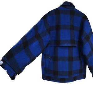 Puede incluir: Chaqueta a cuadros azules y negros con cuello y pu&ntilde;os abotonados. La chaqueta tiene un bolsillo en la parte inferior derecha y una solapa en la parte superior de la espalda. La chaqueta es de un material grueso y c&aacute;lido.