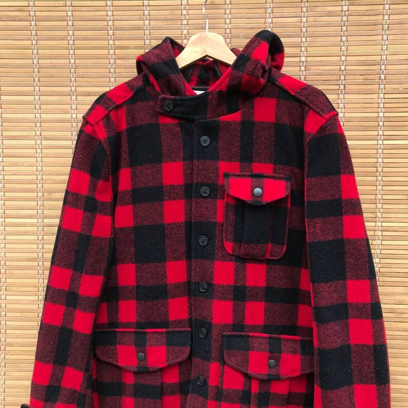 May include: A red and black plaid hooded flannel jacket with multiple pockets and button closures.