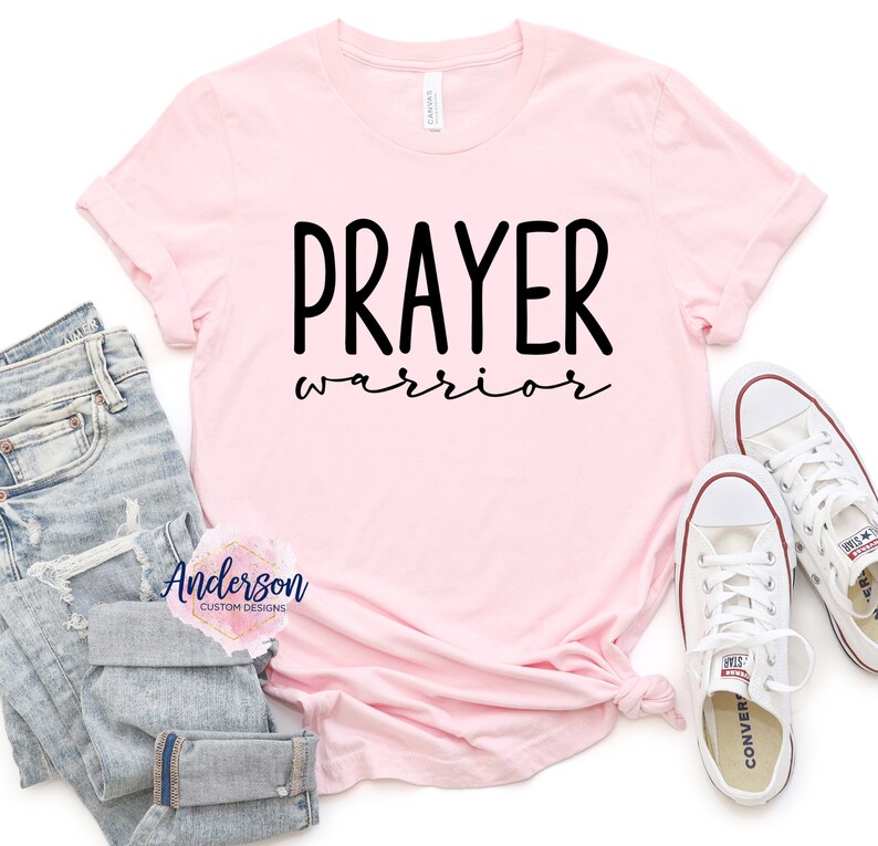 May include: Pink t-shirt with the text "PRAYER warrior" in black lettering.
