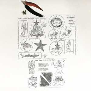 May include: Black and white printable Christmas decorations featuring Australian themes.  The ornaments include a seahorse, starfish, turtle, shark, Christmas tree, penguin, koala, gumboot, and a jar of Vegemite.  The text on the page reads "Ocean Christmas Decorations" and "Iconic Aussie Christmas Decorations".