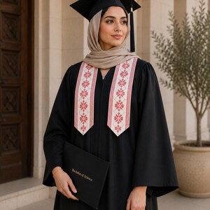 Puede incluir: Una persona con toga y birrete negros, y una estola con bordados florales rojos y blancos. Sostiene un portadocumentos negro con la inscripción "Bachelor of Science".