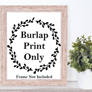 May include: A framed print on burlap with a black floral wreath and the text "Burlap Print Only" and "Frame Not Included".