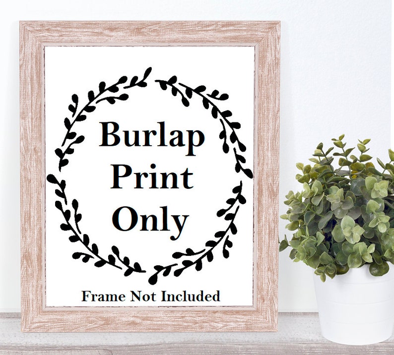 May include: A framed print on burlap with a black floral wreath and the text "Burlap Print Only" and "Frame Not Included".