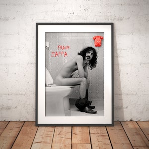 Puede incluir: Fotografía en blanco y negro de Frank Zappa sentado en un inodoro en un baño. La foto está enmarcada y tiene un teléfono rojo en la pared sobre Zappa.