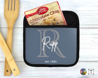 May include: A blue pot holder with a black border and a white monogram "R" with the name "Rupp" and the text "est. 1993".
