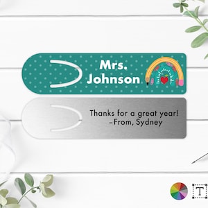 May include: Two bookmark designs. The top bookmark is teal with white polka dots and the text "Mrs. Johnson". It features a pencil, apple, and school supplies design. The bottom bookmark is silver with the text "Thanks for a great year! -From, Sydney".