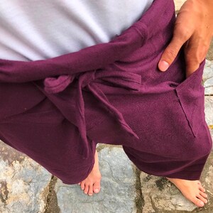 Pu&ograve; includere: Un paio di pantaloni viola con la vita a coulisse. I pantaloni sono realizzati in un tessuto morbido e confortevole e hanno una vestibilit&agrave; rilassata.