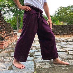 Pu&ograve; includere: Un paio di pantaloni da pescatore thailandesi di colore viola, noti anche come "pantaloni da pescatore" o "pantaloni sarong", sono realizzati in un tessuto morbido e leggero. I pantaloni sono legati in vita con una fascia e hanno una vestibilit&agrave; ampia e fluida.