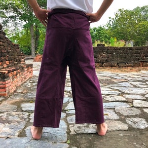 Pu&ograve; includere: Un paio di pantaloni larghi di colore viola con vita a coulisse.