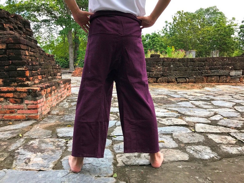 Pu&ograve; includere: Un paio di pantaloni larghi di colore viola con vita a coulisse.