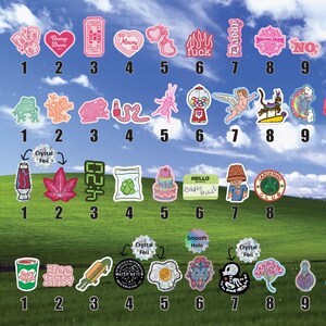 a collection of colorful stickers with various designs and text, arranged in a grid-like pattern against a backdrop of a grassy field and a blue sky with clouds.