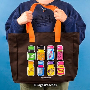 Op de afbeelding: Een donkerbruine tote bag met feloranje hengsels voorzien van een grafische print van acht kleurrijke kleine flesjes. De flesjes zijn gelabeld met tekst waaronder Bolt, Buzz, Super, Raver, Label, Liquid, Nitro Silver en TNT, plus PagesPeaches.