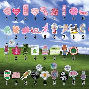 a collection of colorful stickers with various designs and text, arranged in a grid-like pattern against a backdrop of a grassy field and a blue sky with clouds.