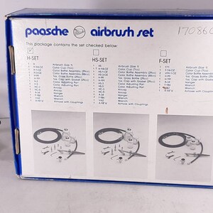 Peut inclure: Une bo&icirc;te bleue et blanche avec le texte "paasche airbrush set" et le num&eacute;ro "1708600". La bo&icirc;te contient une liste des articles inclus dans l'ensemble, y compris un a&eacute;rographe, des gobelets &agrave; peinture, des flacons de peinture et d'autres accessoires.