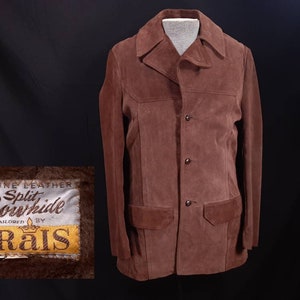 May include: A brown suede jacket with a button closure and a patch on the left breast that reads "Genuine Leather Split Cowhide Tailored by Grais".