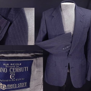 May include: A navy blue pinstripe blazer with a single button closure. The blazer has a label that reads "Rue Royale Designed by Nino Cerruti Paris Tailored in the U.S.A. for K-G men's store".