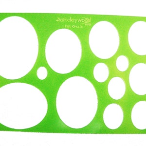 May include: Green plastic stencil with multiple oval shapes of varying sizes. The stencil is labeled "Fancywork USA Fat Ovals".