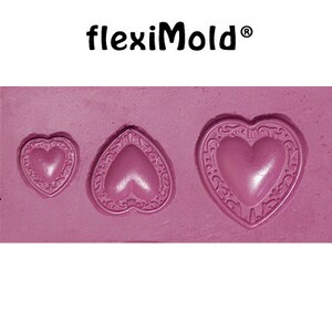 May include: A pink silicone mold with three heart-shaped cavities. The largest heart has a decorative border. The mold is for making chocolate or other treats.