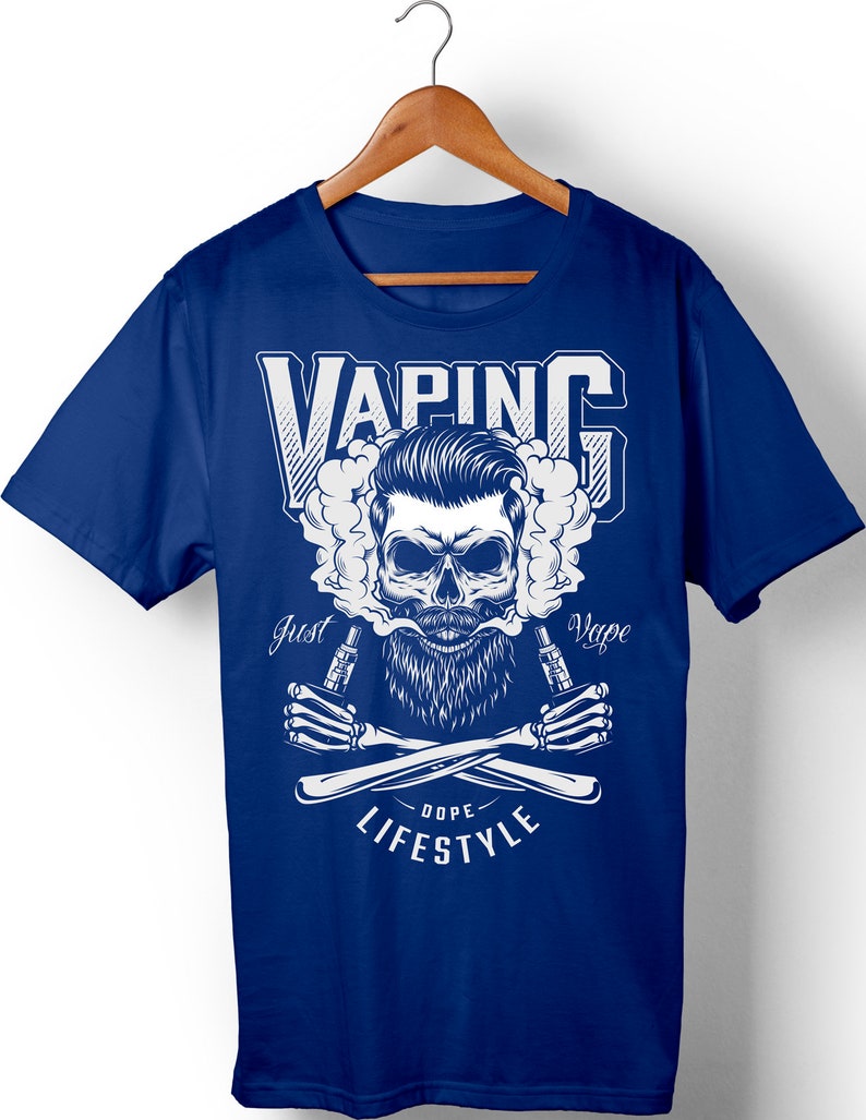 Peut inclure: Un t-shirt bleu avec un motif blanc repr&eacute;sentant un cr&acirc;ne avec une barbe et une moustache, tenant deux stylos vape. Le cr&acirc;ne est entour&eacute; de nuages de vapeur. Le texte "VAPING" est au-dessus du cr&acirc;ne, et le texte "Just Vape" est en dessous du cr&acirc;ne. Le texte "Dope Lifestyle" est en dessous des stylos vape.