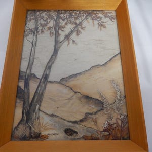May include: A framed artwork featuring a pressed flower and leaf design depicting a landscape with trees and hills. The artwork is signed "M. Zotto" in the bottom right corner.
