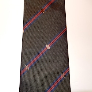 以下が含まれることがあります： 濃いグレーのネクタイ。斜めの赤と青のストライプ模様。薄いベージュ色の「DG」の文字が繰り返されるパターン。ネクタイは、織り目のある生地で作られています。