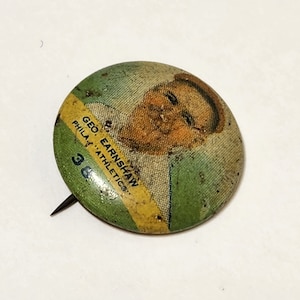 May include: A vintage green and yellow button featuring a photo of baseball player Geo. Earnshaw, Phila. Athletics, #38.