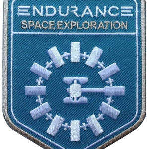 May include: A blue and white embroidered patch with the text "ENDURANCE SPACE EXPLORATION" and a stylised image of a circular space station.