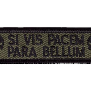 Op de afbeelding: Een groene en zwarte geborduurde patch met de tekst "Si Vis Pacem Para Bellum" en twee schedel afbeeldingen.