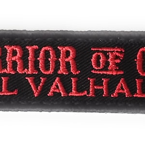 Puede incluir: Parche bordado negro con texto rojo que dice "Warrior of Odin - Till Valhalla - "