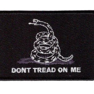 Peut inclure: Écusson brodé noir avec un serpent blanc enroulé et le texte "DONT TREAD ON ME".