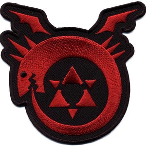 May include: A circular embroidered patch featuring a red Ouroboros serpent biting its own tail, surrounding a central red six-pointed star composed of triangles. The design is set against a black background with a thick black stitched border.