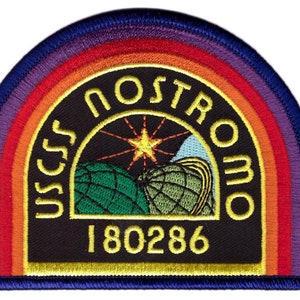 Op de afbeelding: Een zwart en geel geborduurd patch met een regenboogrand. De patch heeft de tekst "USCSS NOSTROMO" in een cirkel rond een gestileerd beeld van een planeet met een ster erboven. Het nummer "180286" is onder de afbeelding gedrukt.