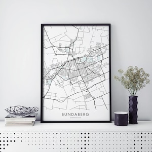May include: A black and white map print of Bundaberg, Queensland, in a black frame. The map shows the city's streets and landmarks.
