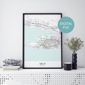 Puede incluir: Una impresión enmarcada del mapa de Split, Croacia, con un marco negro. El mapa es en blanco y negro, sobre un fondo azul claro. Las palabras "SPLIT" y "CROACIA" están impresas en la parte inferior. Un círculo turquesa con las palabras "ARCHIVO DIGITAL" está en la parte superior derecha.