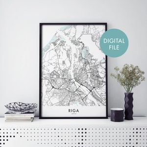 Op de afbeelding: Een zwart-witte kaartprint van Riga, Letland, in een zwart frame. De kaart toont de straten en waterwegen van de stad. De tekst "RIGA" en "LATVIA" staat onder de kaart gedrukt.