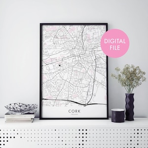 May include: A black and white printable map of Cork, Ireland, with pink highlights. The map is framed in a black frame and the text "DIGITAL FILE" is in a pink circle in the upper right corner of the image.