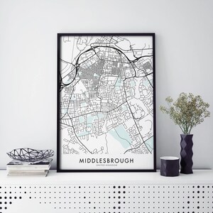 Könnte beinhalten: Schwarz-weiß Druck einer Karte von Middlesbrough, Vereinigtes Königreich, in einem schwarzen Rahmen. Die Karte ist im minimalistischen Stil mit hellblauen Wasserflächen gehalten.