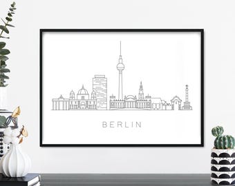 Puede incluir: Impresión en blanco y negro de arte de línea del horizonte de Berlín, con la Puerta de Brandeburgo, el edificio del Reichstag y la Torre de Televisión de Berlín. La impresión está enmarcada en un marco negro y la palabra "BERLIN" está impresa debajo del horizonte.