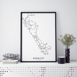 May include: Black and white line art print of a map of Boracay, Philippines, in a black frame on a white shelf with a black and white bowl and two black vases.