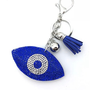 May include: Blue evil eye charm keychain with rhinestones and a blue tassel.