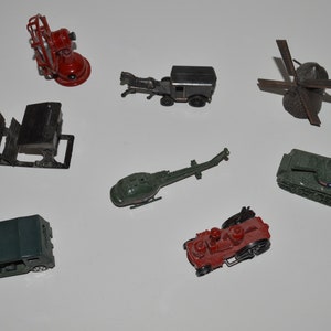 May include: A collection of miniature toy vehicles, including a red fire truck, a green jeep, a green helicopter, a brown horse-drawn carriage, a green tank, a brown train engine, and a brown windmill.