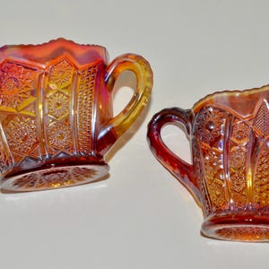 May include: A set of two vintage glass sugar and creamer in a cranberry color with a diamond pattern.