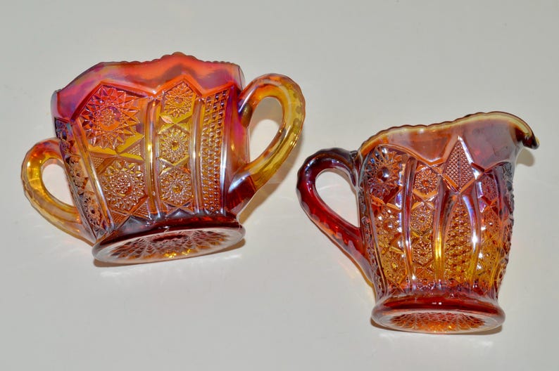 May include: A set of two vintage glass sugar and creamer in a cranberry color with a diamond pattern.